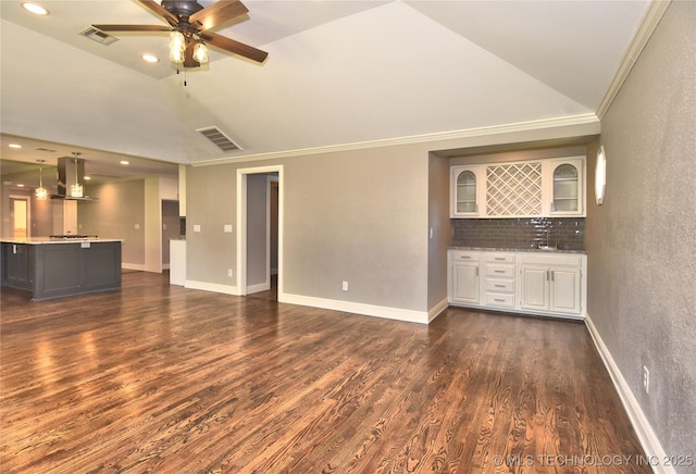 7020 E 89th St, Tulsa, OK 74133 - unfurnished living room featuring dark wood finished floors, a ceiling fan, vaulted ceiling, bar with sink, and ornamental molding