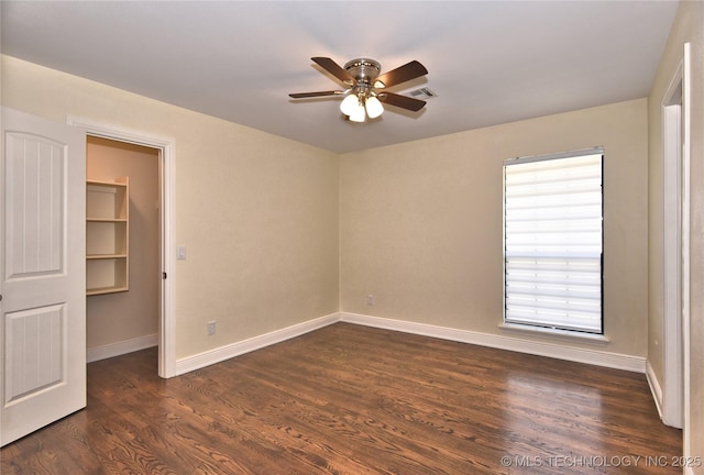 7020 E 89th St, Tulsa, OK 74133 - unfurnished bedroom with a spacious closet, dark wood finished floors, and a ceiling fan