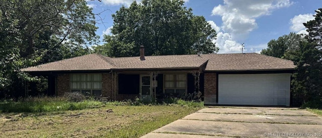 8348 E 7th St S, Tulsa, OK 74112 - single story home featuring concrete driveway, a garage, and brick siding