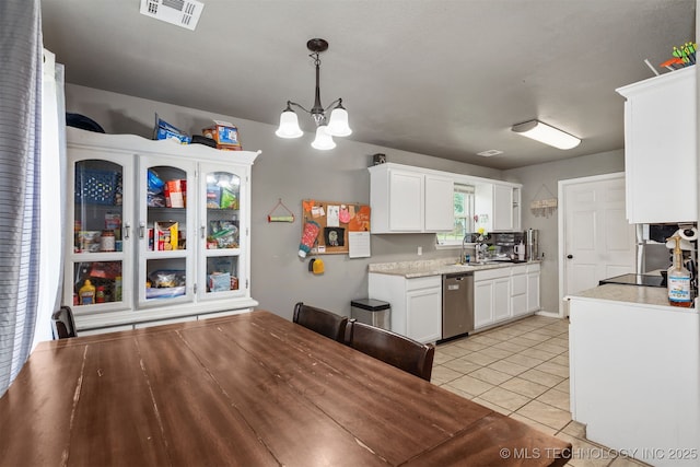 802 NE 9th St, Wagoner, OK 74467 - kitchen with dishwasher, a chandelier, white cabinets, light countertops, and light tile patterned floors