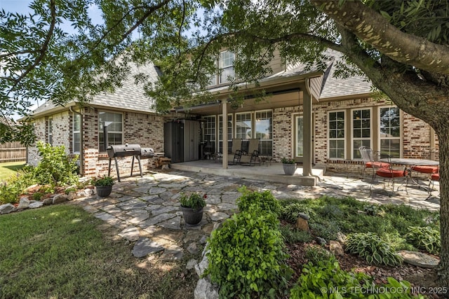 13804 E 90th St, Owasso, OK 74055 - back of house with brick siding, a patio area, and a shingled roof
