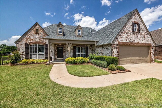 13804 E 90th St, Owasso, OK 74055 - view of front of house featuring brick siding, a shingled roof, a front lawn, and concrete driveway