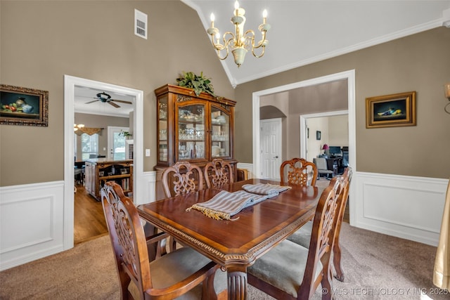 13804 E 90th St, Owasso, OK 74055 - carpeted dining space with a chandelier, a wainscoted wall, crown molding, lofted ceiling, and a decorative wall