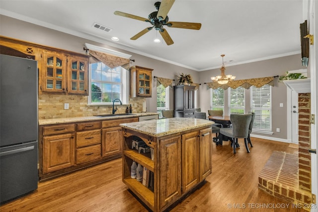 13804 E 90th St, Owasso, OK 74055 - kitchen featuring freestanding refrigerator, brown cabinets, open shelves, a chandelier, and a center island