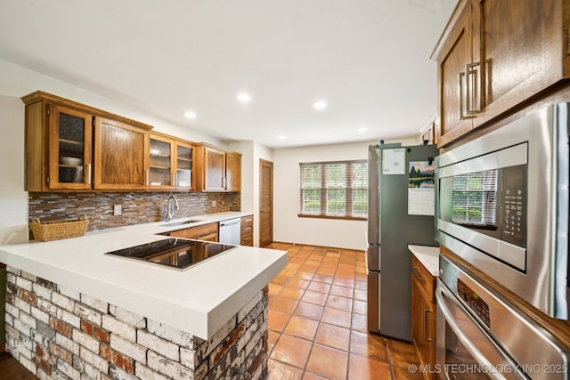 11783 S 252nd E Ave E, Broken Arrow, OK 74014 - kitchen featuring stainless steel appliances, light countertops, backsplash, brown cabinets, and a peninsula