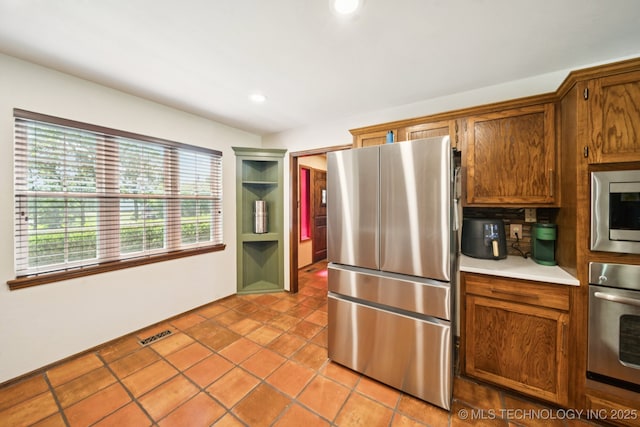 11783 S 252nd E Ave E, Broken Arrow, OK 74014 - kitchen featuring appliances with stainless steel finishes, light countertops, brown cabinetry, recessed lighting, and light tile patterned floors