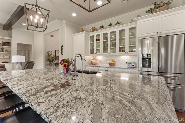 22322 E 121st St S, Broken Arrow, OK 74014 - kitchen with high end refrigerator, a chandelier, white cabinetry, light stone counters, and tasteful backsplash