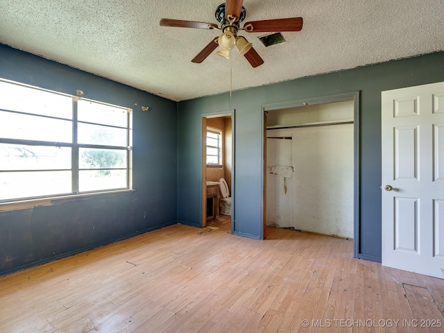 310 E Division, Roff, OK 74865 - unfurnished bedroom with a textured ceiling, a closet, wood finished floors, ensuite bathroom, and ceiling fan