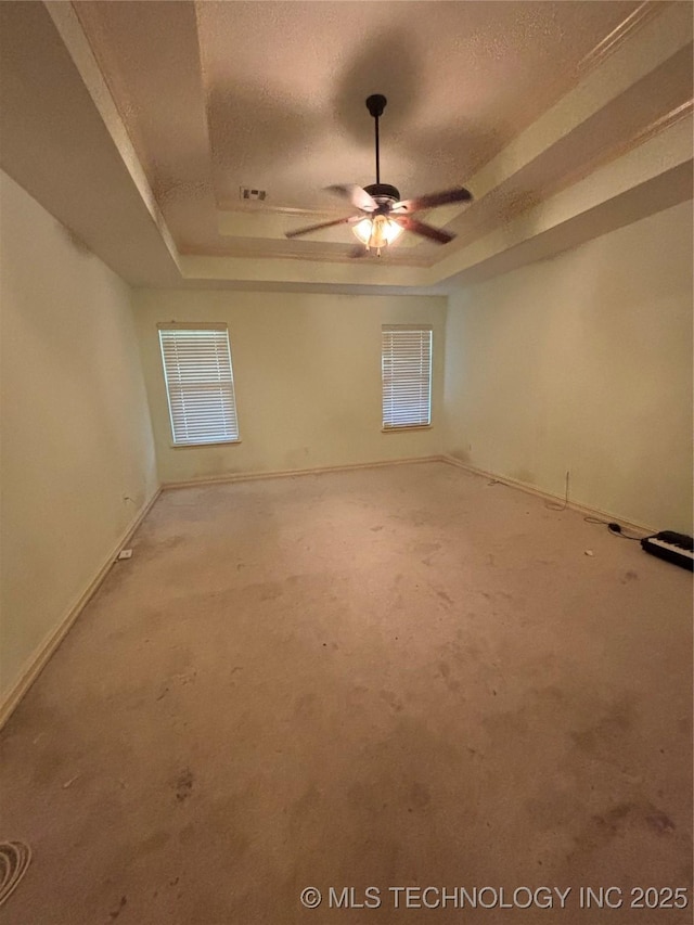 6178 Fulham St, Claremore, OK 74019 - carpeted empty room with a raised ceiling, a ceiling fan, and healthy amount of natural light