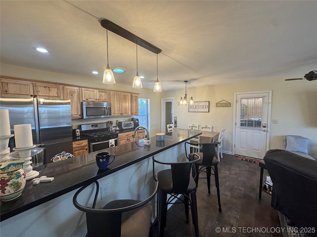 769 Terrace Dr, Prue, OK 74060 - kitchen with appliances with stainless steel finishes, a breakfast bar area, dark countertops, a chandelier, and recessed lighting