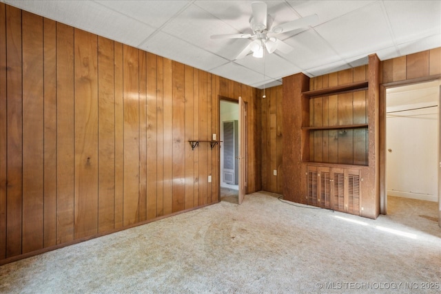 785 US Highway 60, Bartlesville, OK 74003 - unfurnished bedroom featuring carpet, wood walls, and a ceiling fan