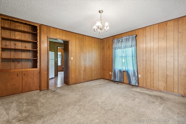 785 US Highway 60, Bartlesville, OK 74003 - carpeted empty room with a chandelier, a textured ceiling, and wood walls