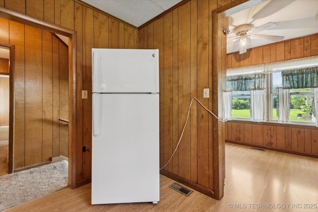 785 US Highway 60, Bartlesville, OK 74003 - kitchen featuring freestanding refrigerator, wood walls, ceiling fan, light wood-style floors, and brown cabinets