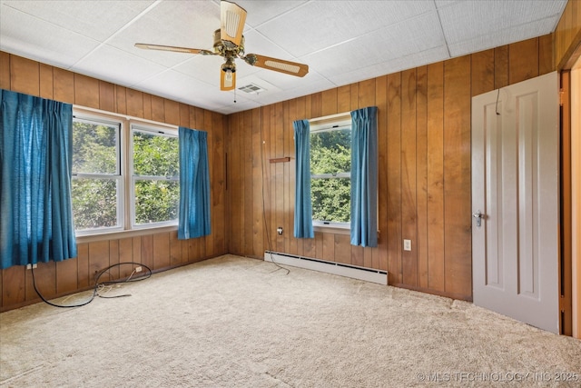 785 US Highway 60, Bartlesville, OK 74003 - empty room featuring a baseboard radiator, carpet floors, wooden walls, and ceiling fan