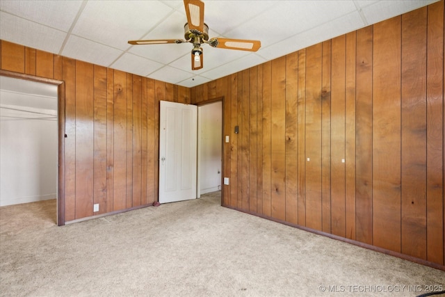 785 US Highway 60, Bartlesville, OK 74003 - unfurnished bedroom with carpet flooring, wooden walls, and ceiling fan