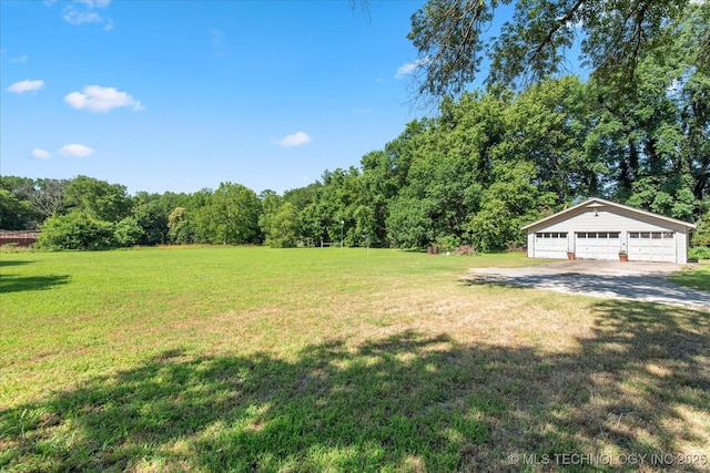 785 US Highway 60, Bartlesville, OK 74003 - view of grassy yard with a garage, an outbuilding, and a view of trees