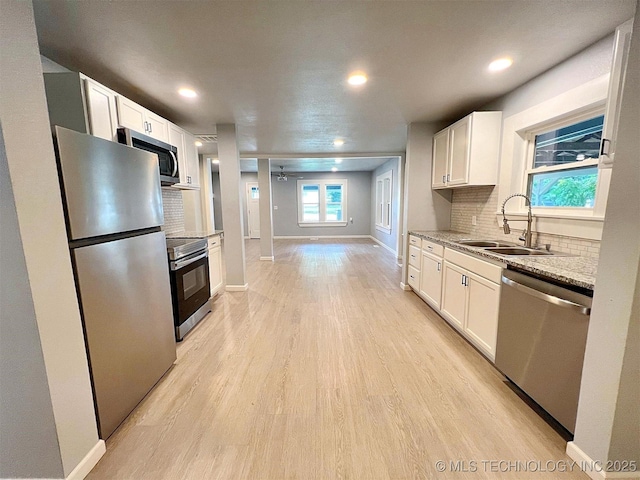 609 E Ward St, Tahlequah, OK 74464 - kitchen featuring stainless steel appliances, decorative backsplash, white cabinets, light wood-type flooring, and recessed lighting