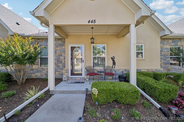 445 S Cypress Ave, Broken Arrow, OK 74012 - doorway to property featuring stone siding, stucco siding, and covered porch