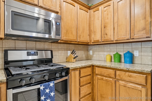 445 S Cypress Ave, Broken Arrow, OK 74012 - kitchen featuring appliances with stainless steel finishes, light stone counters, and backsplash