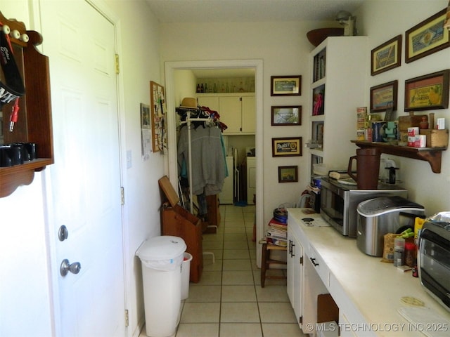 399987 W 3700th Rd, Ramona, OK 74061 - hallway featuring light tile patterned flooring and washing machine and dryer