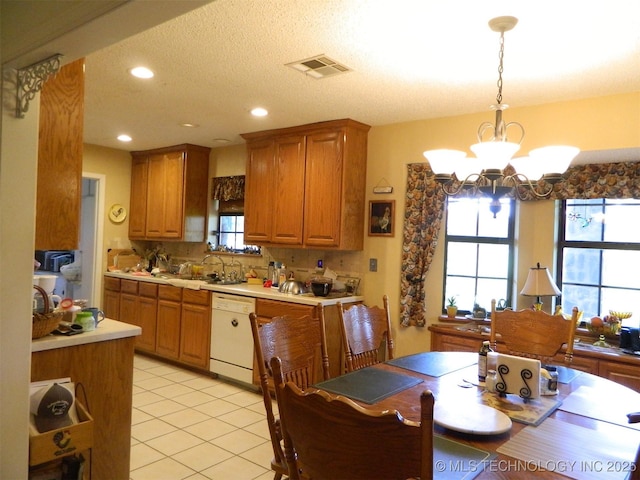 399987 W 3700th Rd, Ramona, OK 74061 - kitchen with dishwasher, a chandelier, light countertops, brown cabinetry, and light tile patterned floors