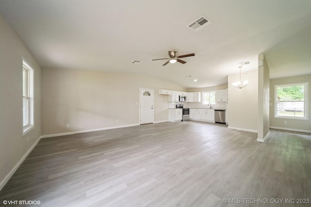 25530 S 608th Ct, Grove, OK 74344 - unfurnished living room featuring a ceiling fan, a chandelier, light wood-style flooring, and vaulted ceiling