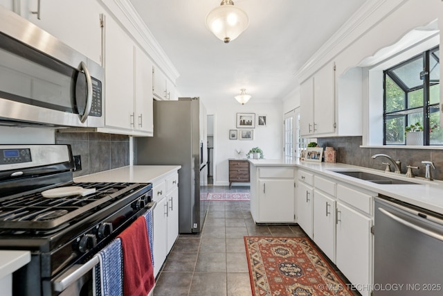 4019 E 37th St S, Tulsa, OK 74135 - kitchen featuring stainless steel appliances, white cabinetry, light countertops, decorative backsplash, and crown molding