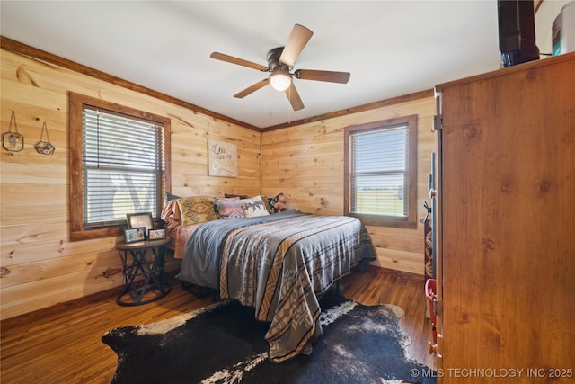 719 Oklahoma Ave, Wynona, OK 74084 - bedroom featuring wood walls, wood finished floors, and ceiling fan