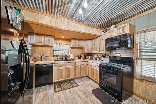 719 Oklahoma Ave, Wynona, OK 74084 - kitchen with black appliances, light brown cabinetry, light countertops, light wood-type flooring, and decorative backsplash