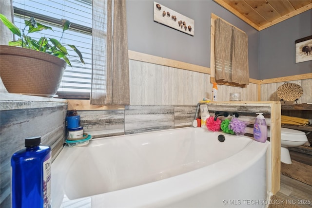 719 Oklahoma Ave, Wynona, OK 74084 - bathroom with wainscoting, a bath, wood walls, and wood ceiling