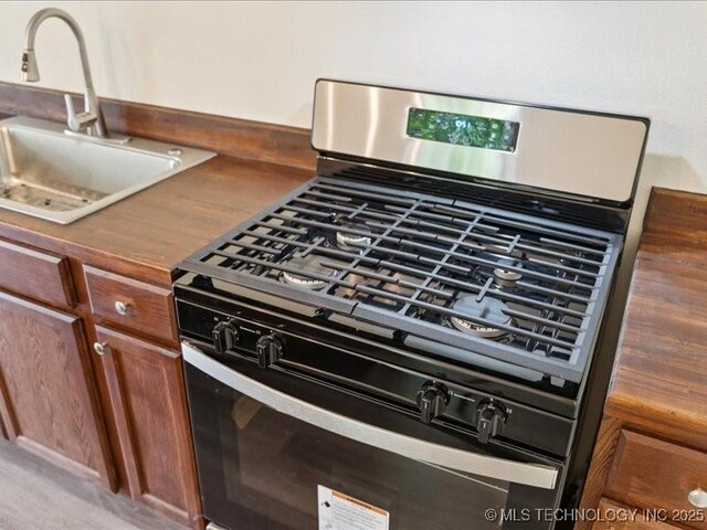 409 N Cherokee St, Claremore, OK 74017 - kitchen view of stainless steel gas stove and brown cabinetry