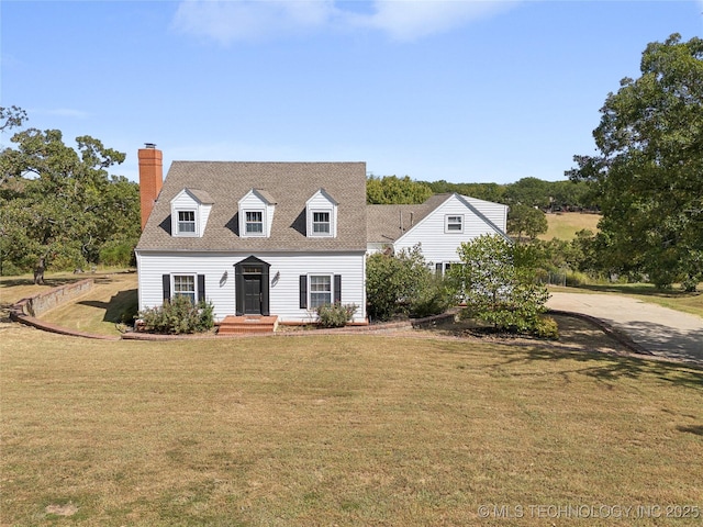407 N Wildflower Run, Bristow, OK 74010 - cape cod house featuring a chimney, a front yard, and roof with shingles
