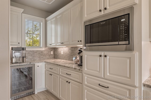 449 E 129th Pl, Jenks, OK 74037 - kitchen with wine cooler, black microwave, white cabinetry, decorative backsplash, and light stone counters