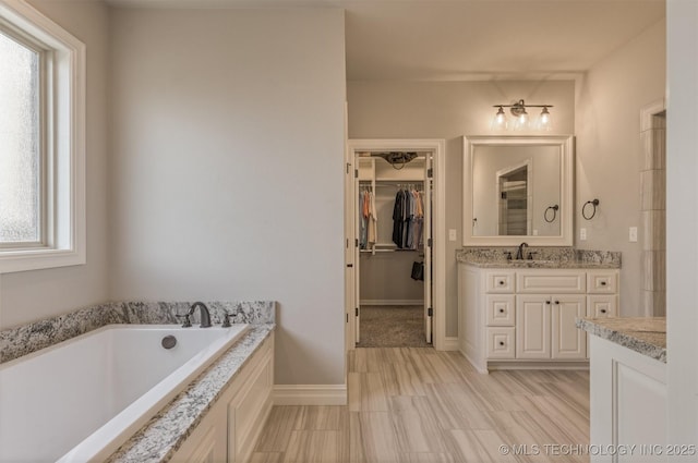 449 E 129th Pl, Jenks, OK 74037 - bathroom featuring vanity, a garden tub, and a walk in closet