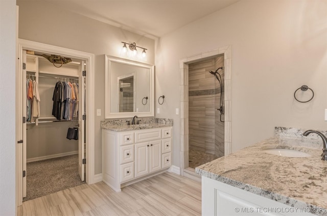 449 E 129th Pl, Jenks, OK 74037 - bathroom featuring two vanities, a shower stall, and a spacious closet