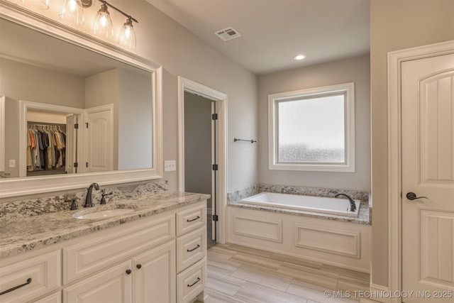 449 E 129th Pl, Jenks, OK 74037 - full bathroom with vanity, a bath, a spacious closet, and recessed lighting