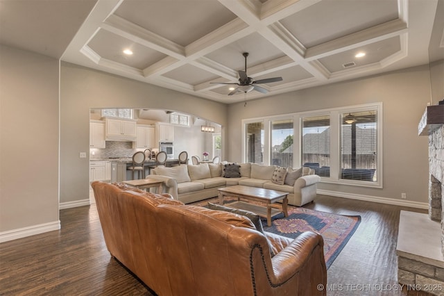449 E 129th Pl, Jenks, OK 74037 - living room with a ceiling fan, a stone fireplace, arched walkways, dark wood-style floors, and beamed ceiling