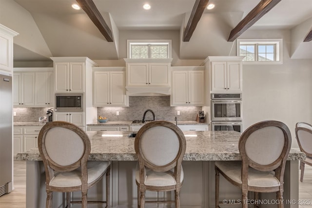 449 E 129th Pl, Jenks, OK 74037 - kitchen with appliances with stainless steel finishes, tasteful backsplash, a kitchen breakfast bar, healthy amount of natural light, and recessed lighting