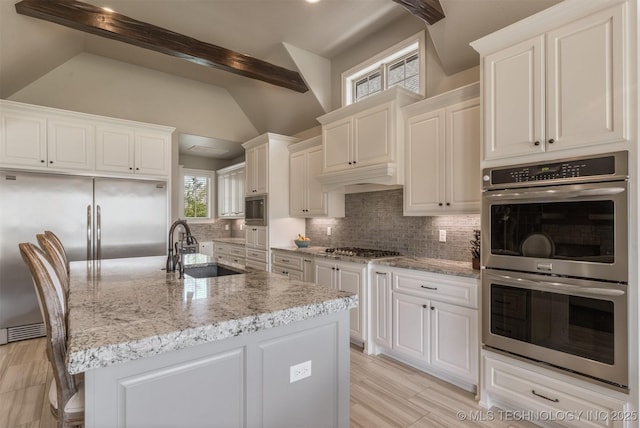 449 E 129th Pl, Jenks, OK 74037 - kitchen featuring built in appliances, decorative backsplash, light stone counters, and white cabinets