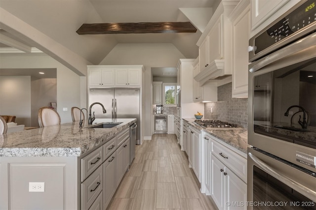 449 E 129th Pl, Jenks, OK 74037 - kitchen featuring beverage cooler, appliances with stainless steel finishes, decorative backsplash, and white cabinets