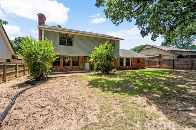 7033 E 99th St, Tulsa, OK 74133 - rear view of house with brick siding, a chimney, and a fenced backyard