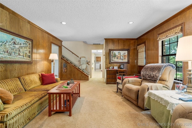 7033 E 99th St, Tulsa, OK 74133 - living room featuring wood walls, light carpet, ornamental molding, a textured ceiling, and recessed lighting