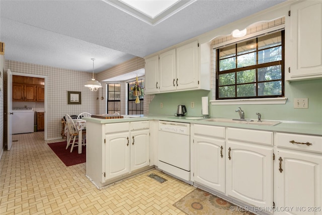 7033 E 99th St, Tulsa, OK 74133 - kitchen featuring white dishwasher, wallpapered walls, a peninsula, a textured ceiling, and separate washer and dryer