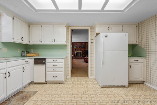 7033 E 99th St, Tulsa, OK 74133 - kitchen featuring freestanding refrigerator, light countertops, and white cabinets