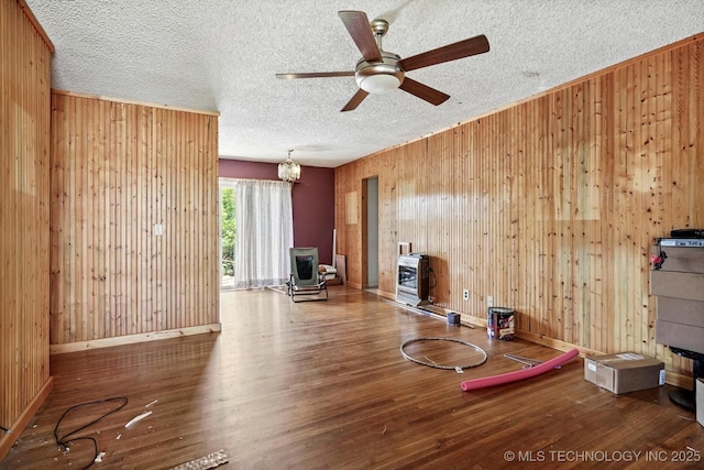 705 W Hartford Pl, Broken Arrow, OK 74012 - living room with a wood stove, wood walls, wood finished floors, ceiling fan, and a textured ceiling