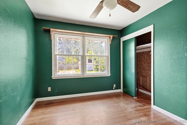 705 W Hartford Pl, Broken Arrow, OK 74012 - unfurnished bedroom with a textured wall, wood finished floors, a closet, and a ceiling fan