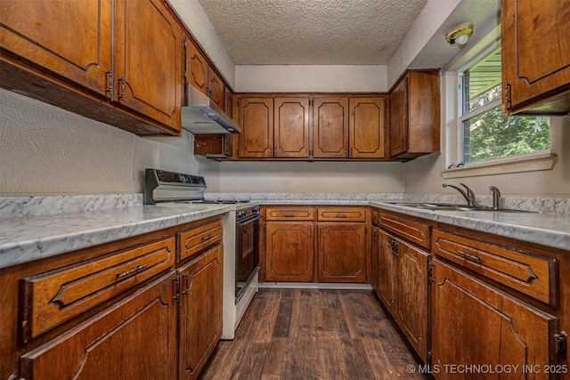 807 E Tahlequah, Sulphur, OK 73086 - kitchen featuring electric stove, under cabinet range hood, dark wood-type flooring, a textured ceiling, and brown cabinetry