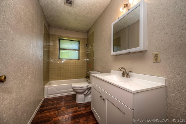 807 E Tahlequah, Sulphur, OK 73086 - bathroom featuring a textured wall, wood finished floors, vanity, bathing tub / shower combination, and a textured ceiling