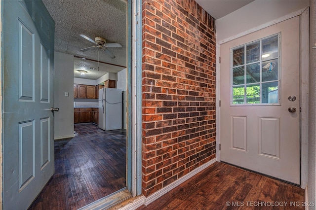 807 E Tahlequah, Sulphur, OK 73086 - doorway with dark wood finished floors, a ceiling fan, and brick wall