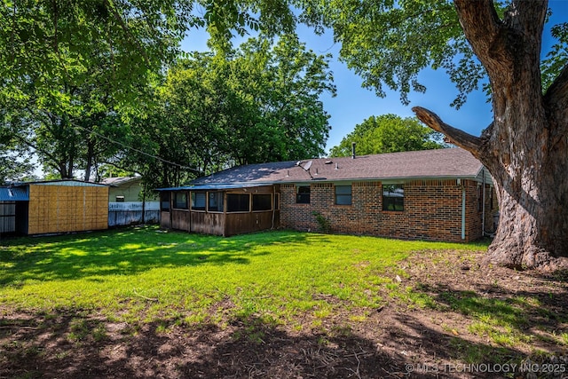 807 E Tahlequah, Sulphur, OK 73086 - rear view of property with a sunroom, brick siding, and a storage unit